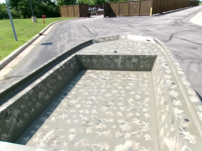 Slide: The Image of 2025 Tracker Grizzly 1754 Jon boat with camouflage interior on a paved road. - 3