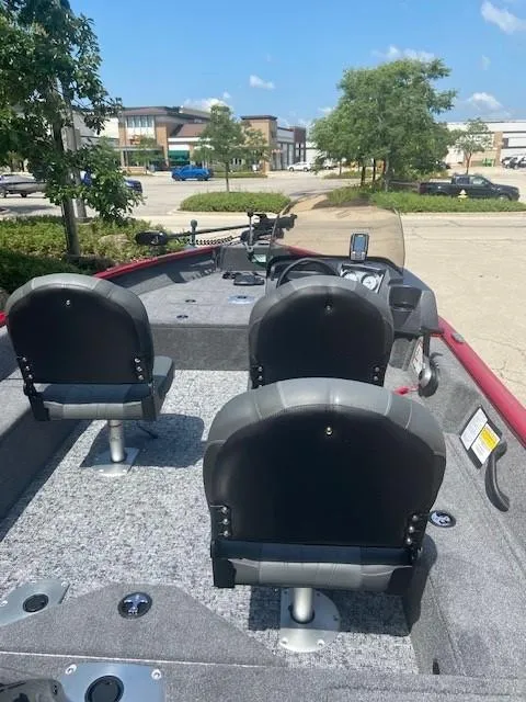 Slide: The Image of 2025 Tracker Pro Guide V-16 SC boat with seating, parked outdoors. - 2