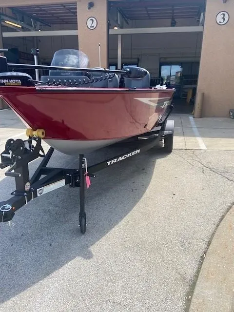 Slide: The Image of 2025 Tracker Pro Guide V-16 SC boat on trailer, parked outside garage. - 5