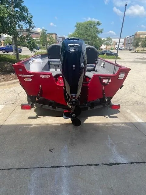 Slide: The Image of 2025 Tracker Pro Guide V-16 SC boat, red exterior, parked outdoors. - 6