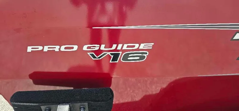 Slide: The Image of 2025 Tracker Pro Guide V-16 SC boat logo on red surface. - 2