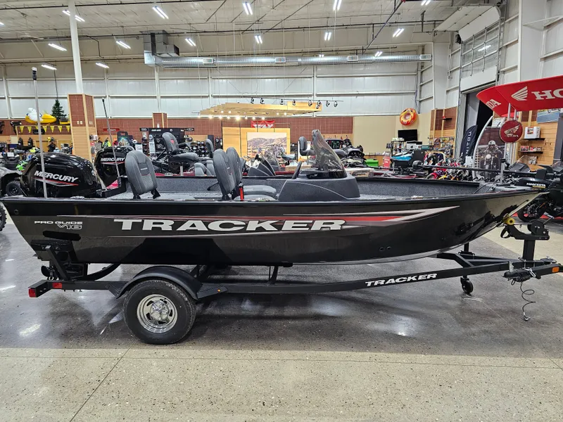 The Image of 2025 Tracker Pro Guide V-16 SC boat displayed indoors on a trailer. - 0