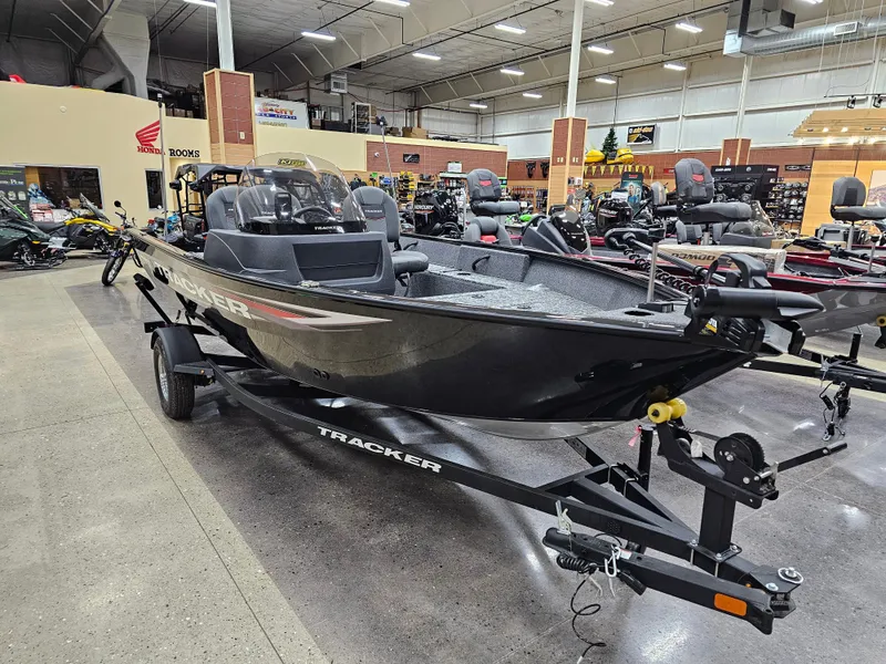 Slide: The Image of 2025 Tracker Pro Guide V-16 SC boat displayed in showroom on trailer. - 2