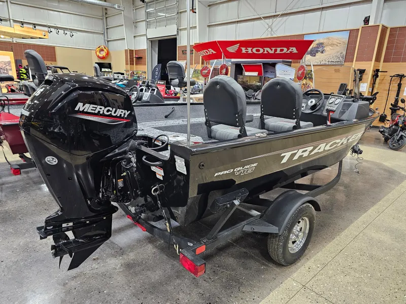 Slide: The Image of 2025 Tracker Pro Guide V-16 SC boat with Mercury engine on display in showroom. - 3