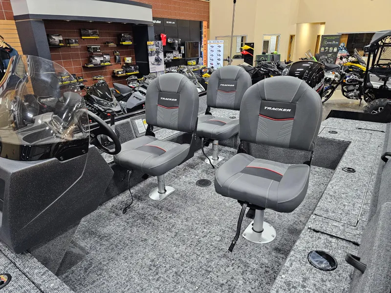 Slide: The Image of 2025 Tracker Pro Guide V-16 SC boat interior with three gray seats in showroom. - 8