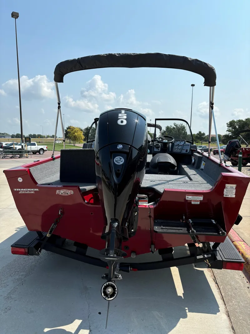 Slide: The Image of 2025 Tracker Pro Guide V-175 Combo boat with outboard motor, parked outdoors. - 2