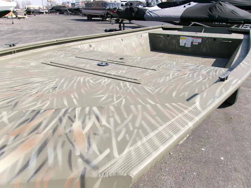 Slide: The Image of 2025 Tracker Grizzly 1648 Jon boat with camouflage pattern, parked outdoors. - 4