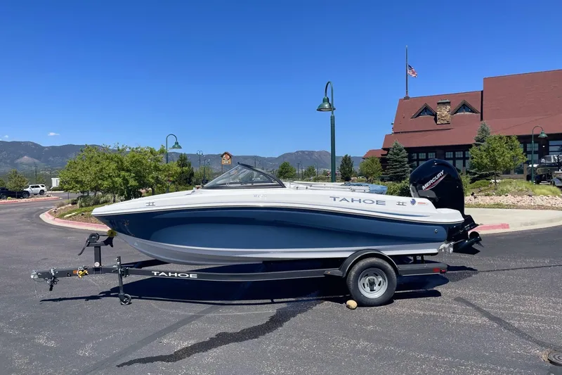 The Image of 2024 Tahoe 185 S boat on trailer, parked outdoors with scenic mountain backdrop. - 0