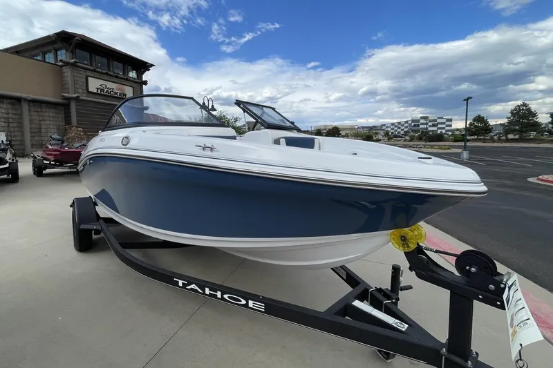Slide: The Image of 2024 Tahoe 185 S boat on trailer, displayed outdoors under a partly cloudy sky. - 3