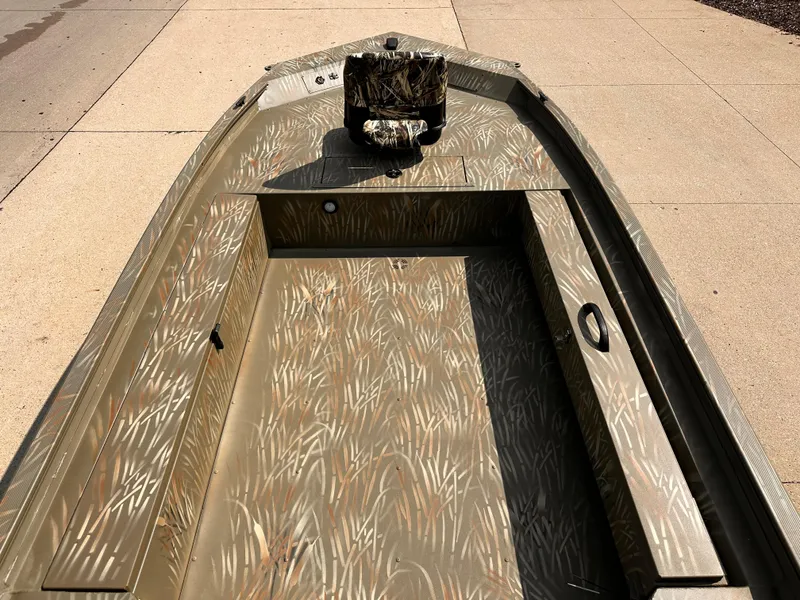 Slide: The Image of 2025 Tracker Grizzly 1654 T Sportsman boat with camouflage interior design. - 4