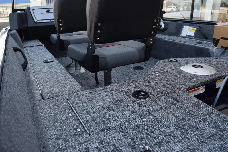 Slide: The Image of 2025 Tracker Pro Guide V-16 WT interior with gray seating and carpeted flooring. - 6