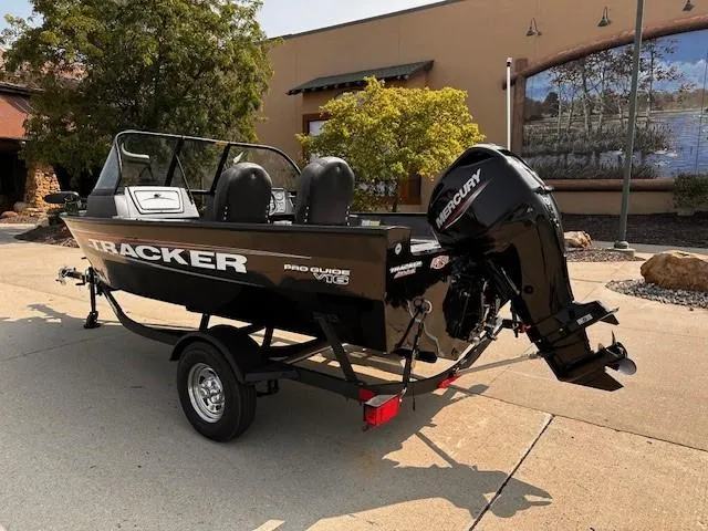 Slide: The Image of 2025 Tracker Pro Guide V-16 WT boat with Mercury outboard motor on trailer. - 2