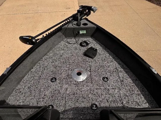 Slide: The Image of 2025 Tracker Pro Guide V-16 WT boat deck with trolling motor and carpeted surface. - 3