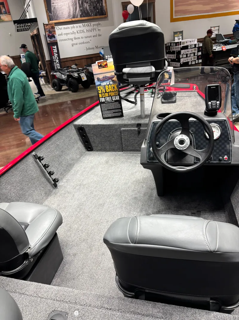 Slide: The Image of 2025 Tracker Bass Tracker Classic XL boat interior with steering wheel and seating. - 2
