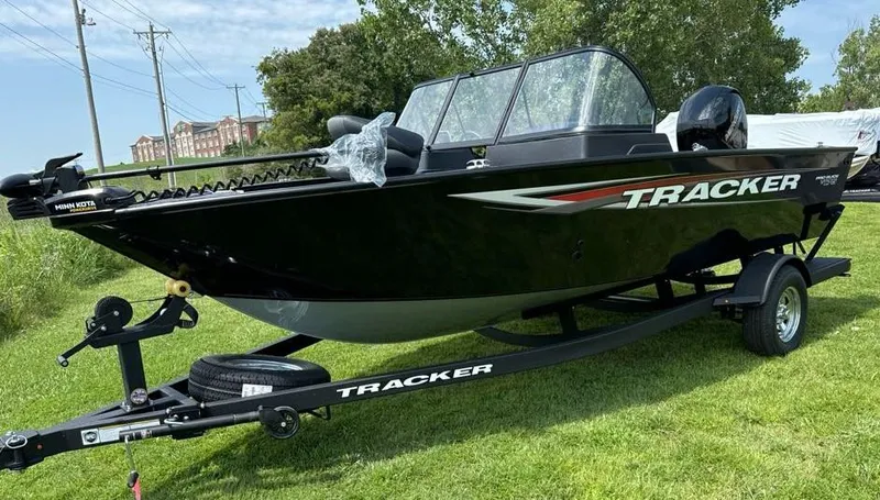 Slide: The Image of 2025 Tracker Pro Guide V-175 Combo boat on trailer, black exterior, parked on grass. - 3