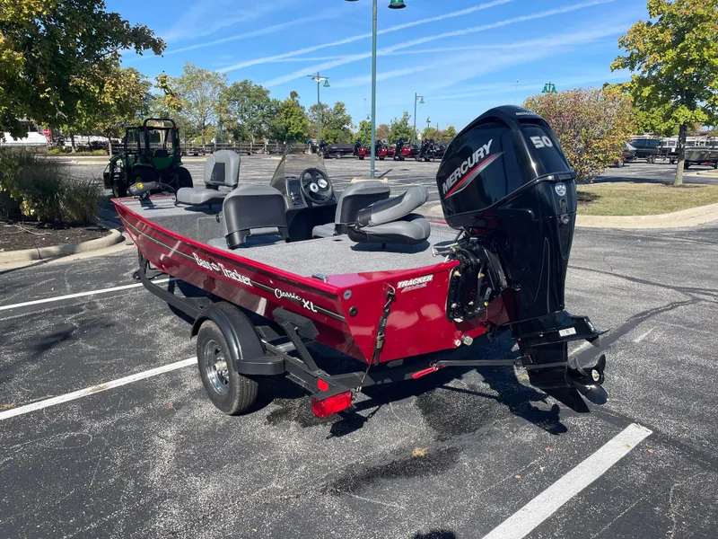 Slide: The Image of 2025 Tracker Bass Tracker Classic XL boat with Mercury engine in parking lot. - 5