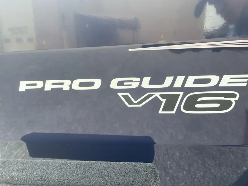 Slide: The Image of 2025 Tracker Pro Guide V-16 WT boat logo on dark surface. - 2