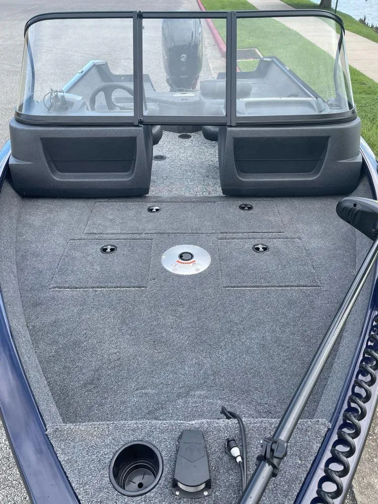 Slide: The Image of 2025 Tracker Pro Guide V-16 WT boat interior with windshield and carpeted deck. - 3
