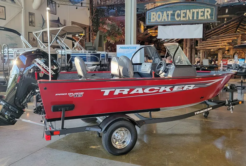 Slide: The Image of 2025 Tracker Pro Guide V-16 WT boat displayed at a boat center showroom. - 3