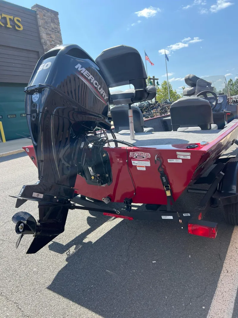 Slide: The Image of 2025 Tracker Bass Tracker Classic XL boat with Mercury engine, parked outdoors. - 2