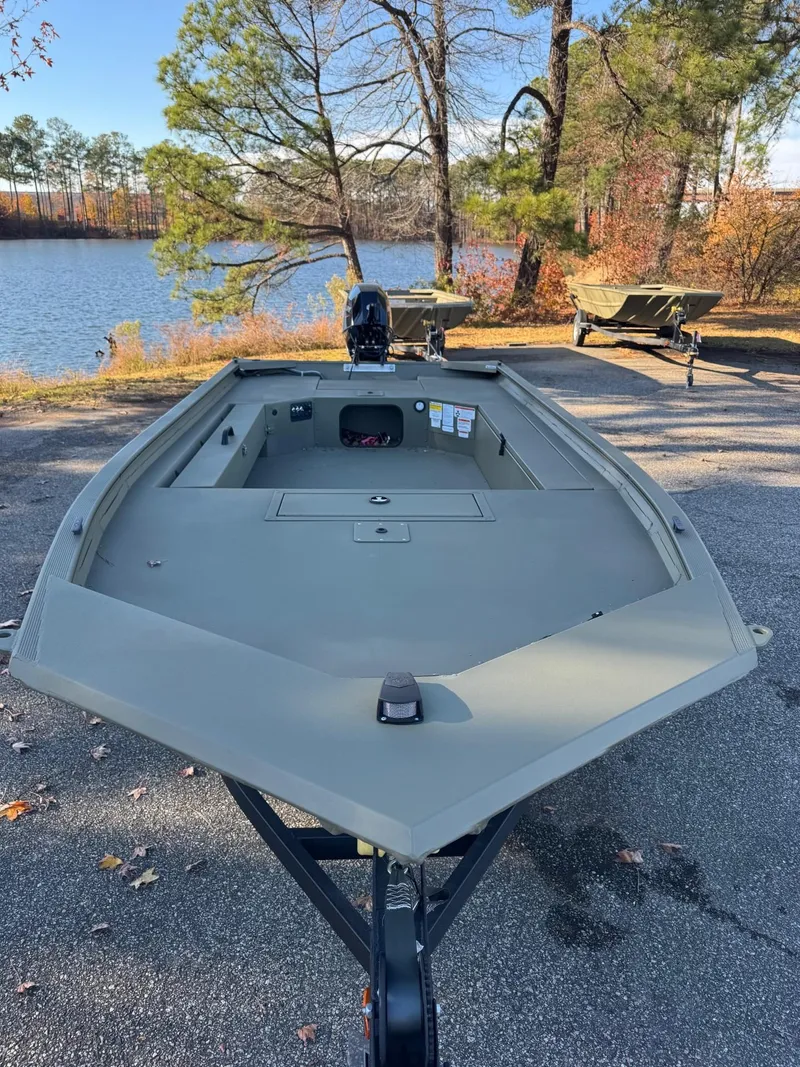 Slide: The Image of 2025 Tracker Grizzly 1654 T Sportsman boat by a scenic lake. - 44