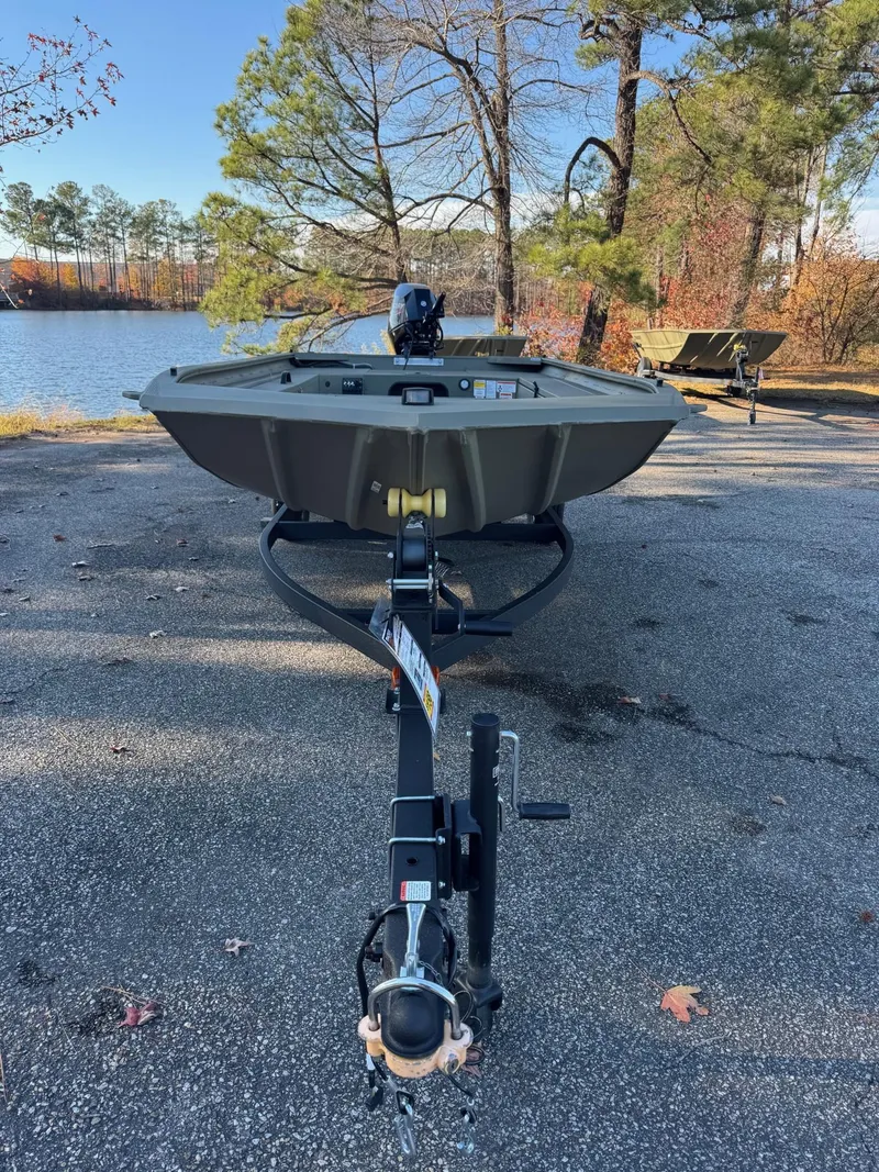 Slide: The Image of 2025 Tracker Grizzly 1654 T Sportsman boat on trailer by lakeside. - 48