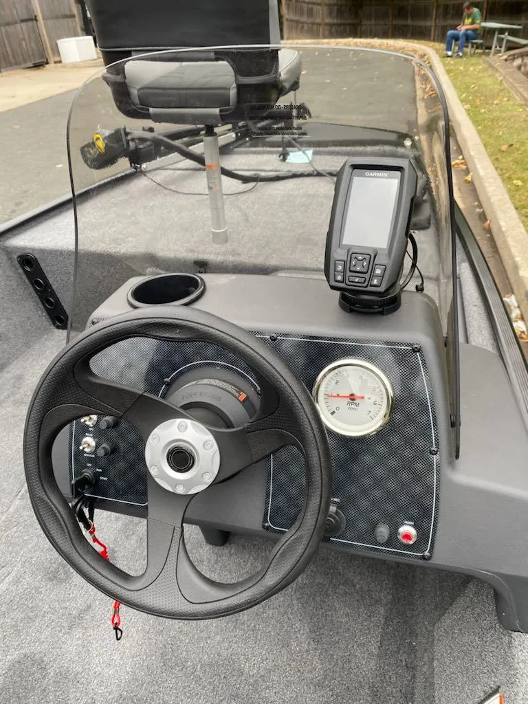 Slide: The Image of 2025 Tracker Bass Tracker Classic XL boat dashboard with steering wheel and navigation system. - 6