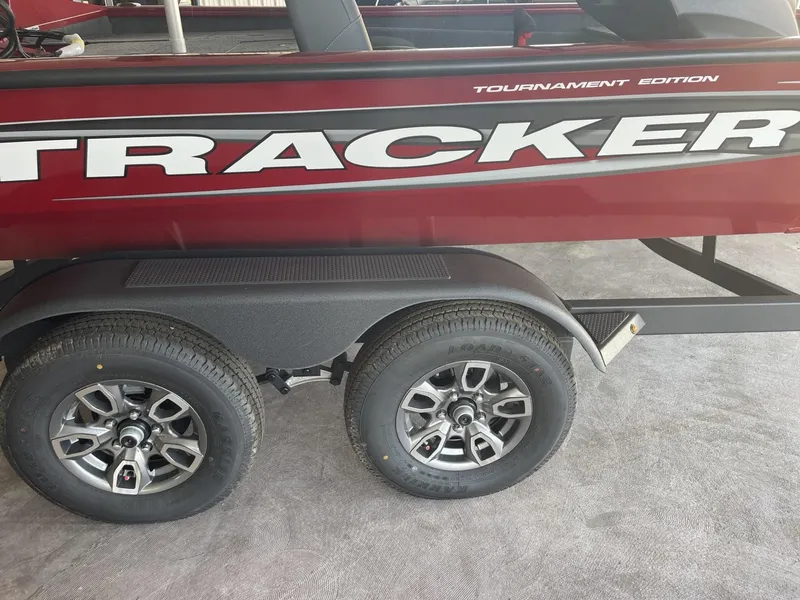 Slide: The Image of 2025 Tracker Pro Team 195 Tournament Edition boat on trailer, featuring dual wheels. - 12