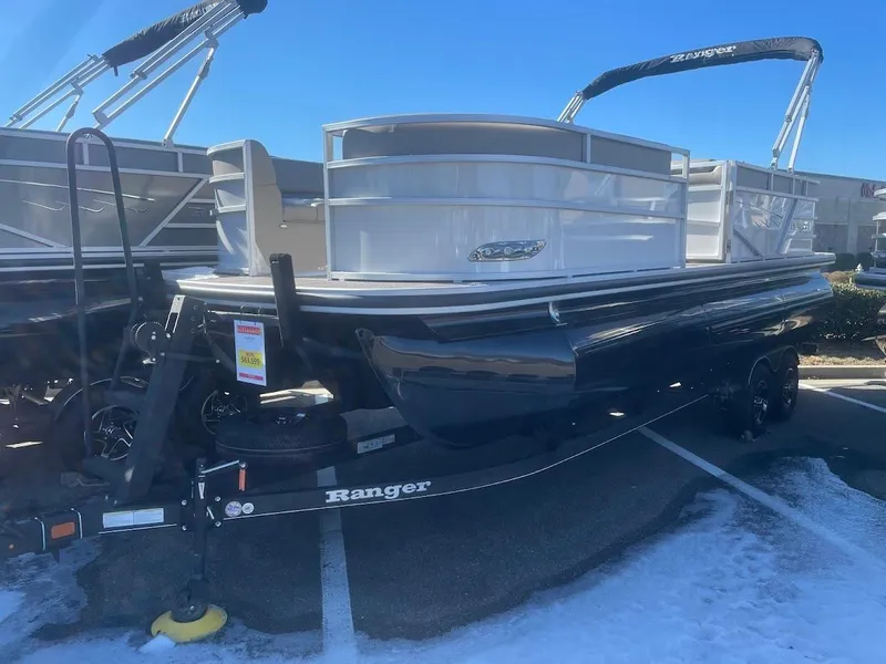 The Image of 2024 Ranger Reata 223C pontoon boat on trailer in parking lot. - 0