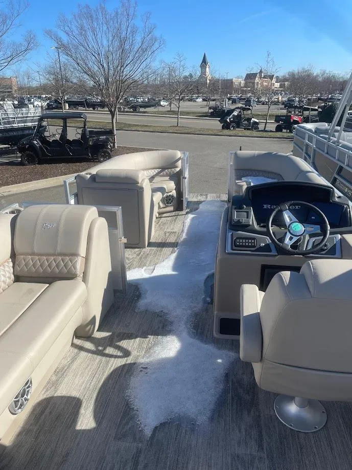 Slide: The Image of 2024 Ranger Reata 223C pontoon boat interior with beige seating and modern dashboard. - 2