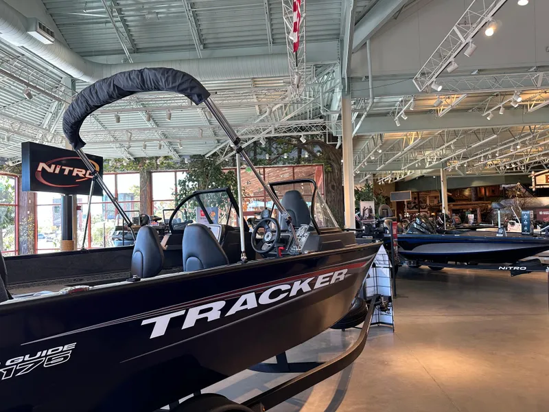 Slide: The Image of 2025 Tracker Pro Guide V-175 Combo boat displayed in a showroom. - 3
