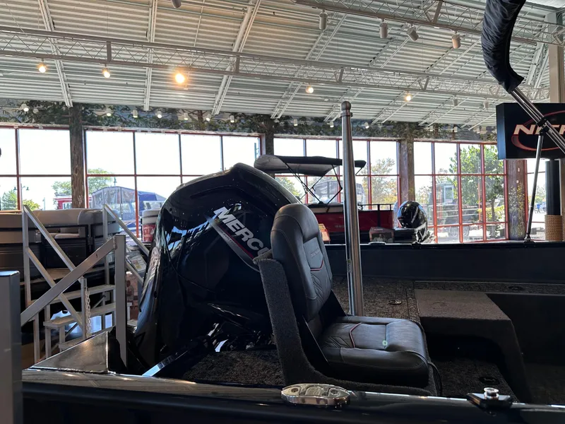 Slide: The Image of 2025 Tracker Pro Guide V-175 Combo boat interior with Mercury engine in showroom. - 4