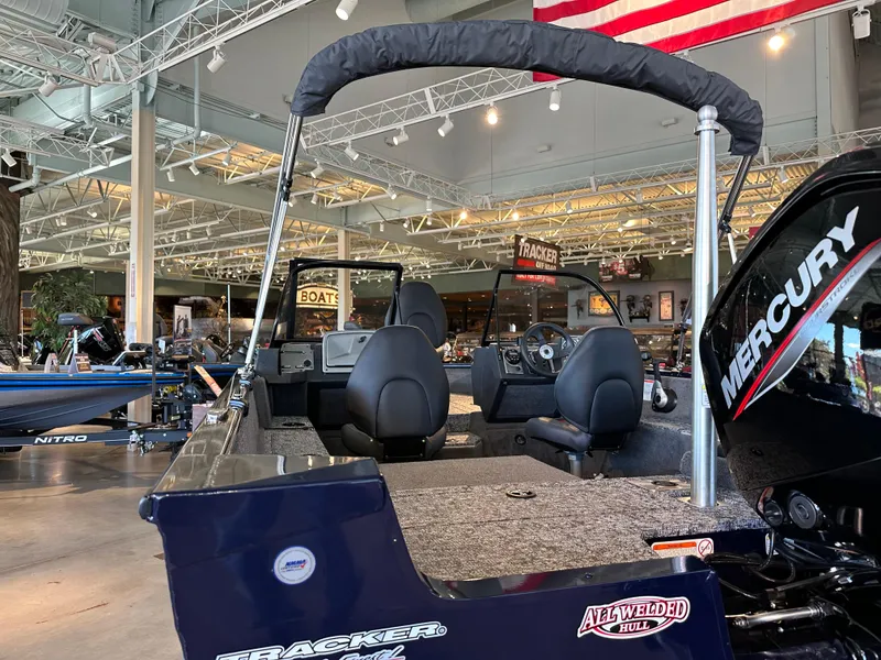 Slide: The Image of 2025 Tracker Pro Guide V-175 Combo boat in showroom, featuring Mercury engine. - 5