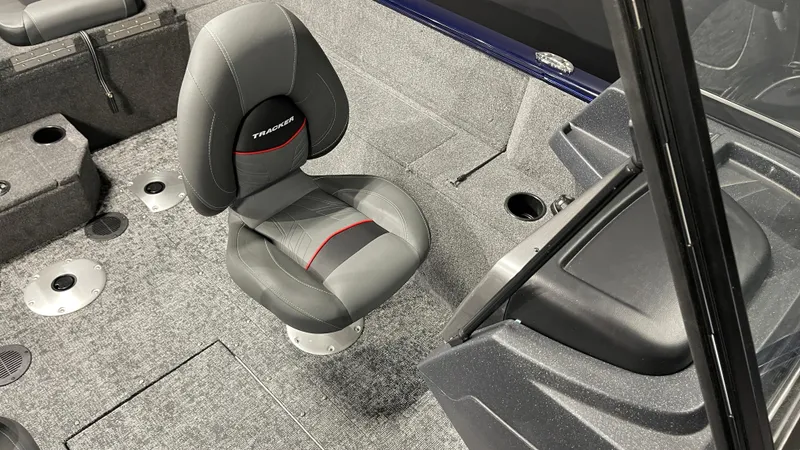 Slide: The Image of 2025 Tracker Pro Guide V-175 Combo boat interior with gray seating and carpeted flooring. - 12