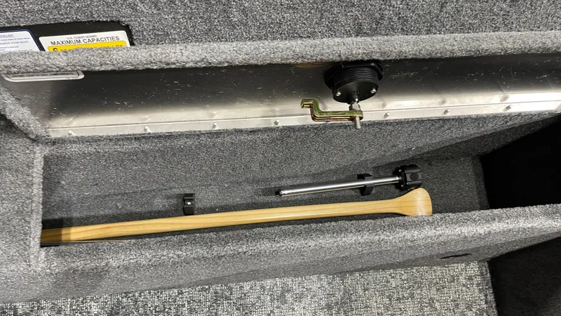 Slide: The Image of Storage compartment of 2025 Tracker Pro Guide V-175 Combo boat with wooden paddle. - 19