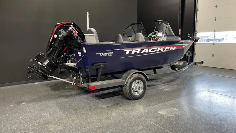 Slide: The Image of 2025 Tracker Pro Guide V-175 Combo boat on trailer in showroom. - 2