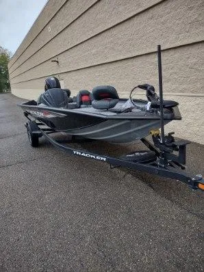 Slide: The Image of 2025 Tracker Pro Team 195 Tournament Edition boat on trailer, parked outdoors. - 2