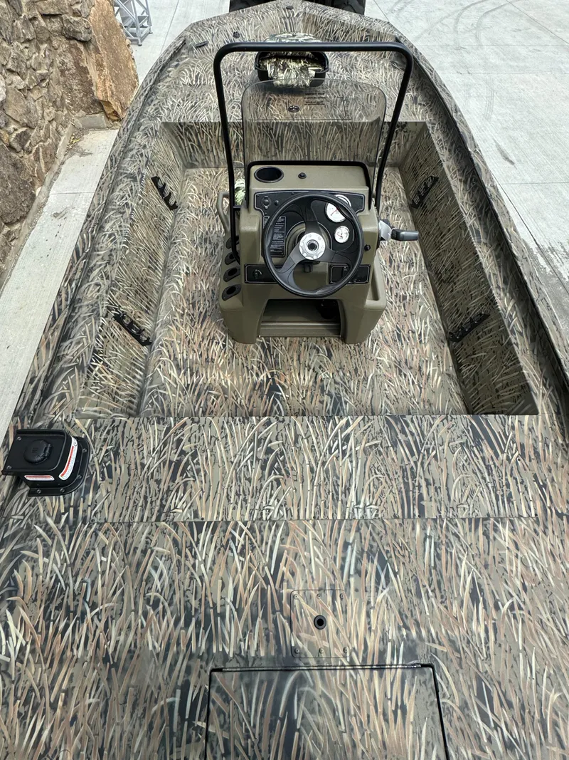 Slide: The Image of 2025 Tracker Grizzly 1860 CC boat with camouflage design and central steering console. - 3