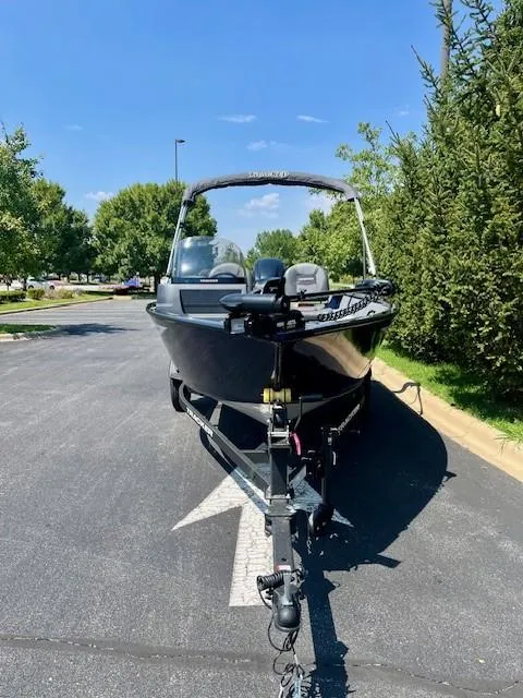 Slide: The Image of 2025 Tracker Pro Guide V-16 SC boat on trailer, parked on sunny street. - 2