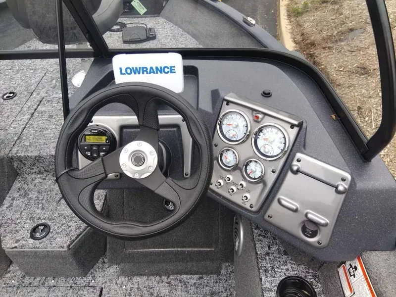 Slide: The Image of 2025 Tracker Pro Guide V-175 Combo boat dashboard with steering wheel and gauges. - 2