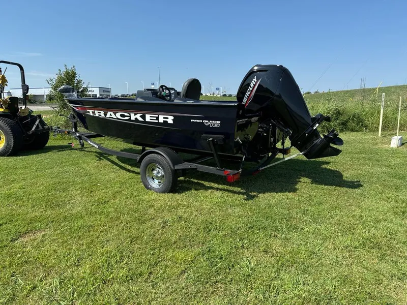 Slide: The Image of 2025 Tracker Pro Guide V-16 SC boat on grassy field, sunny day. - 2