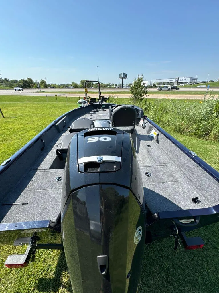 Slide: The Image of 2025 Tracker Pro Guide V-16 SC boat with powerful engine, parked on grass. - 6