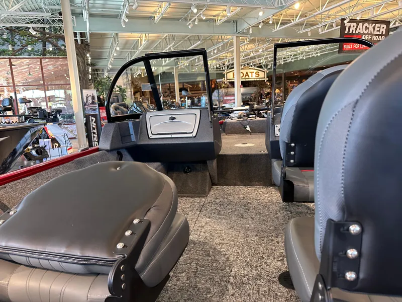 Slide: The Image of 2025 Tracker Pro Guide V-16 WT boat interior with gray seating and carpeted floor. - 3