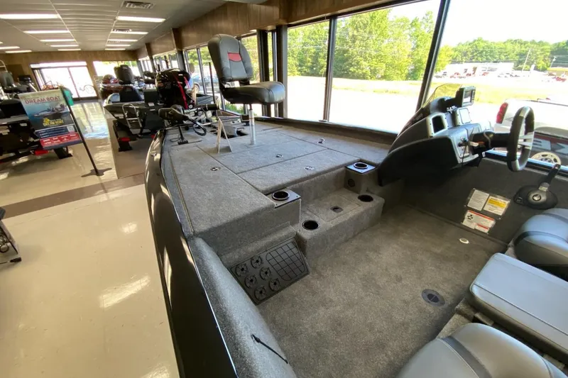 Slide: The Image of 2025 Tracker Pro Team 195 Tournament Edition boat interior in showroom, featuring seating and control panel. - 10