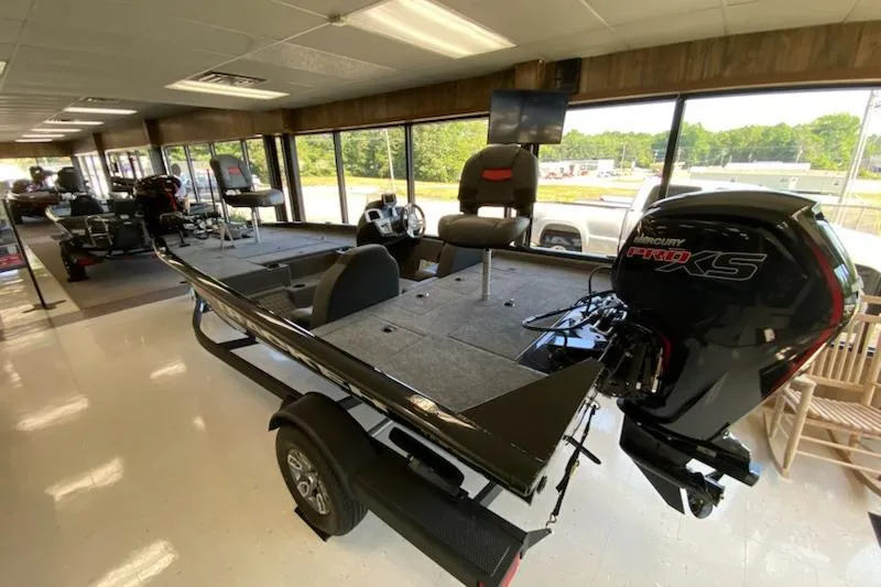 Slide: The Image of 2025 Tracker Pro Team 195 Tournament Edition boat displayed indoors with Mercury engine. - 3