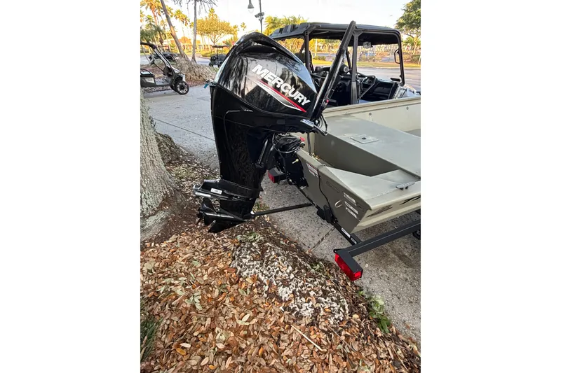 Slide: The Image of 2025 Tracker Grizzly 1648 Jon boat with Mercury outboard motor on a trailer. - 2