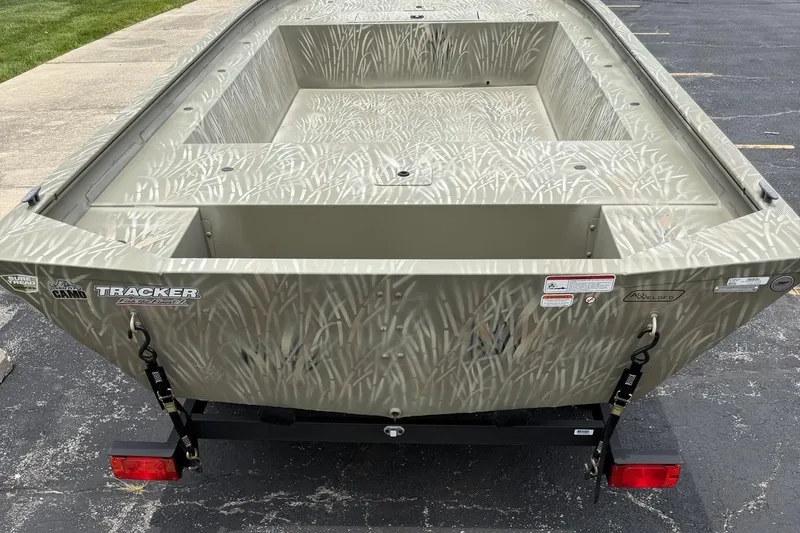 Slide: The Image of 2025 Tracker Grizzly 1754 Jon boat with camouflage design on a trailer. - 3