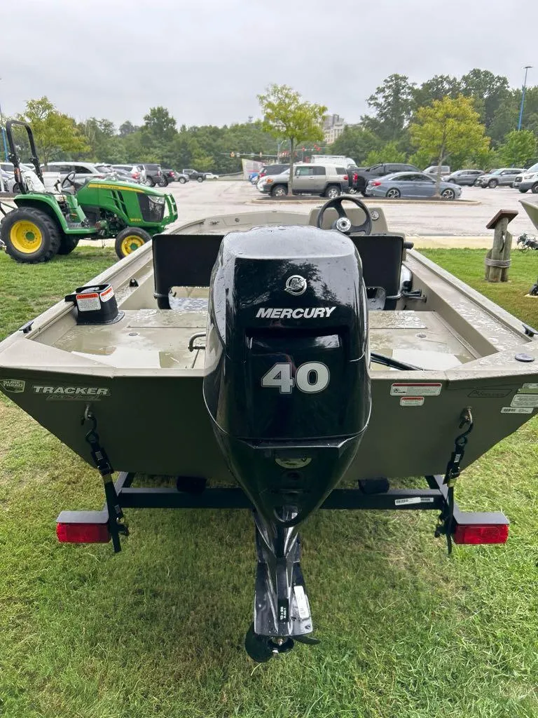 Slide: The Image of 2025 Tracker Grizzly 1754 SC boat with Mercury 40 engine, parked on grass. - 3