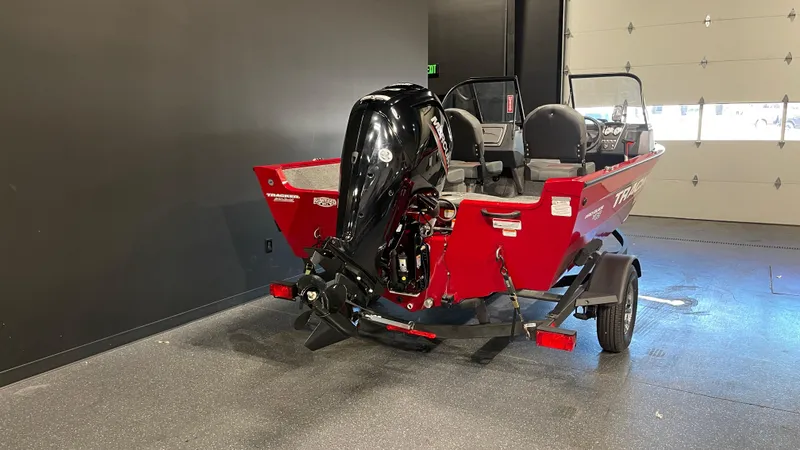 Slide: The Image of 2025 Tracker Pro Guide V-16 WT boat in showroom, red exterior, black motor. - 4
