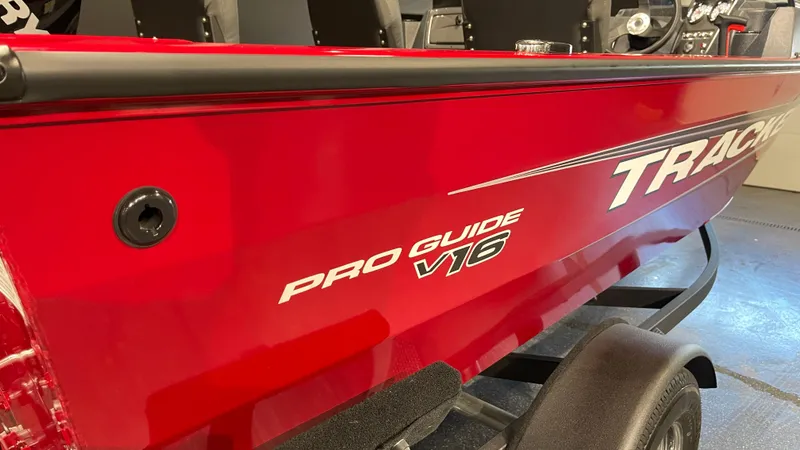 Slide: The Image of 2025 Tracker Pro Guide V-16 WT boat, red exterior, close-up view. - 5